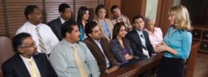 A group of people sitting in front of a wooden table.